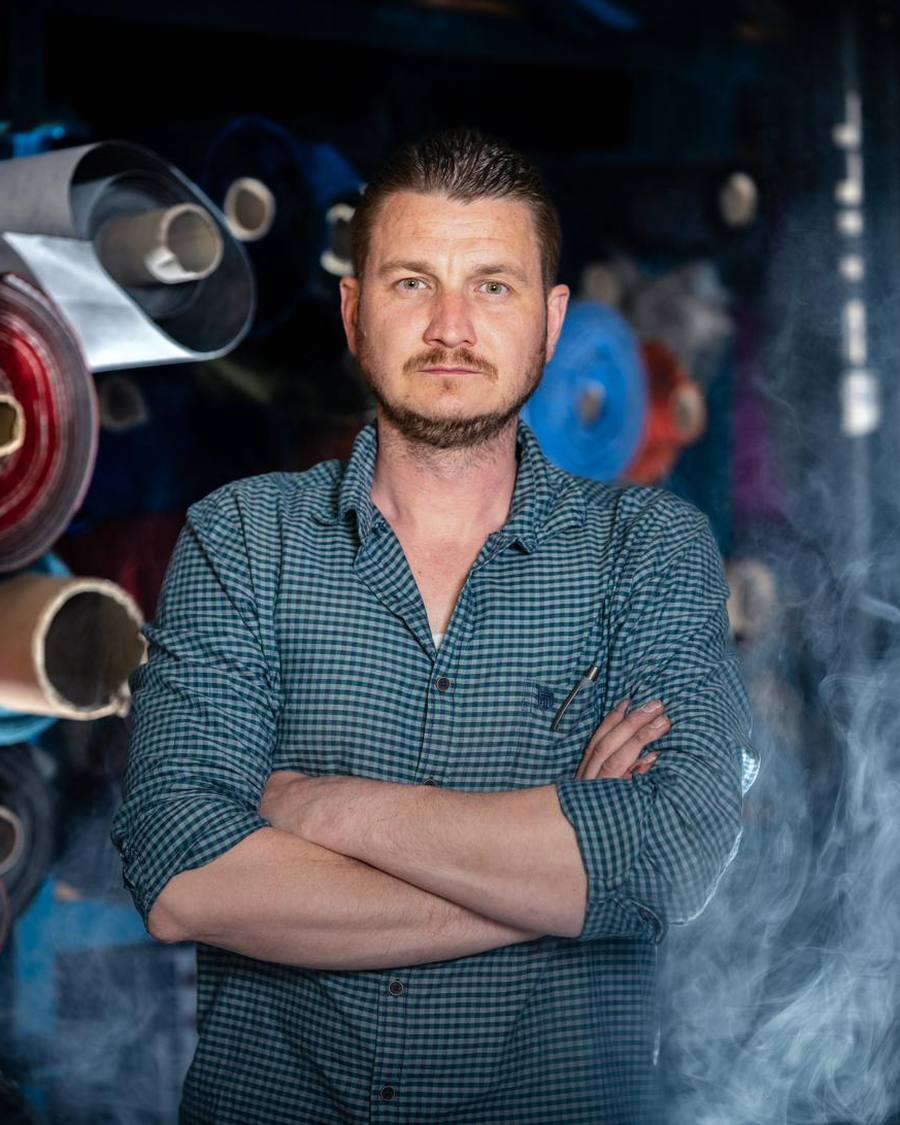 Jan Scholz, Inhaber und Meister, in seiner Werkstatt vor Regalen mit Bezugsstoffen